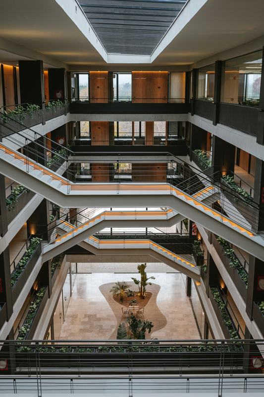 Atrio central de Foresta con escaleras, jardineras y luz natural